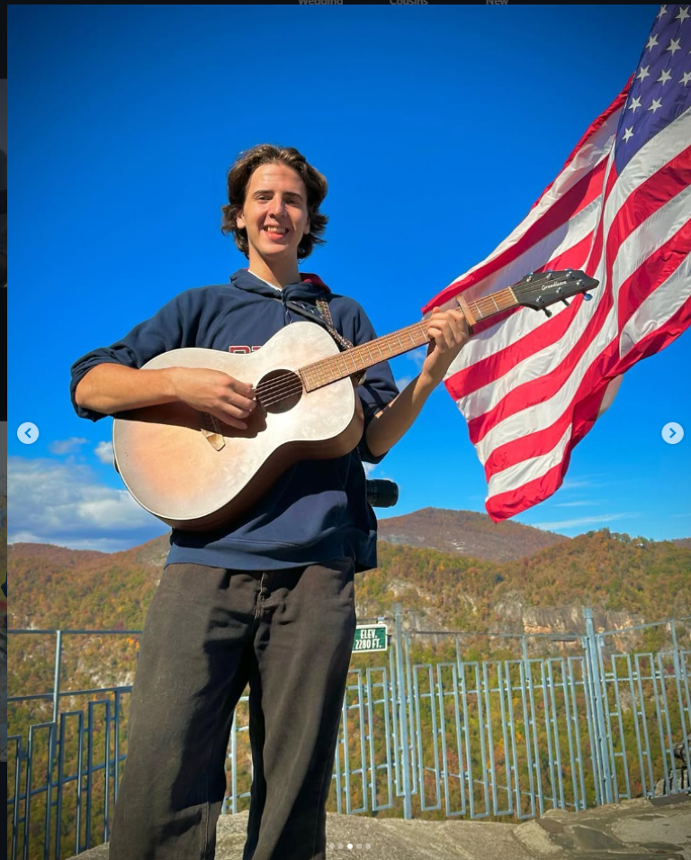 Photo of Bligh Morgan with his guitar infrom of the american flag